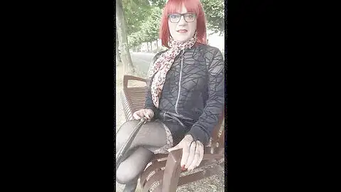 Sophie red-haired crossdresser ambles outside braless